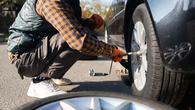 Dc auto care's mechanic performing on-site tire replacement